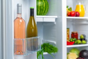 An open fridge with bottles of wine in it